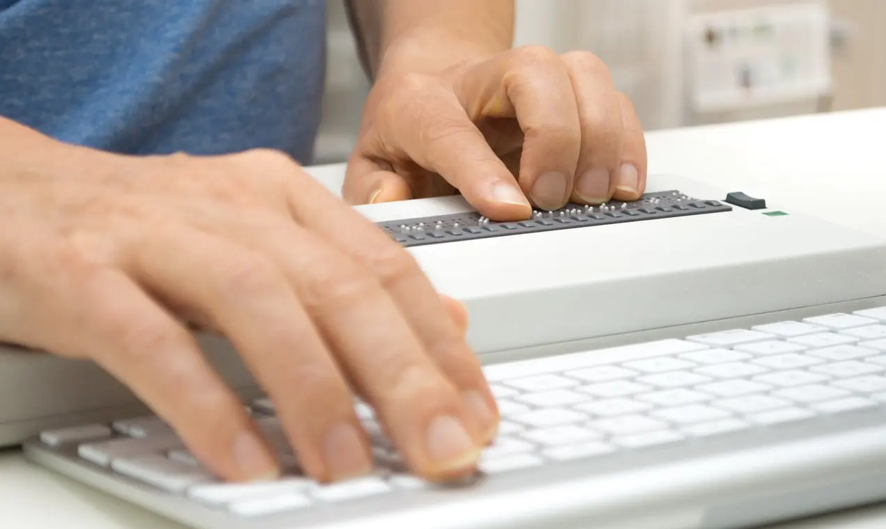 コンピューターで点字リーダーツールを使用しているWebサイト訪問者。