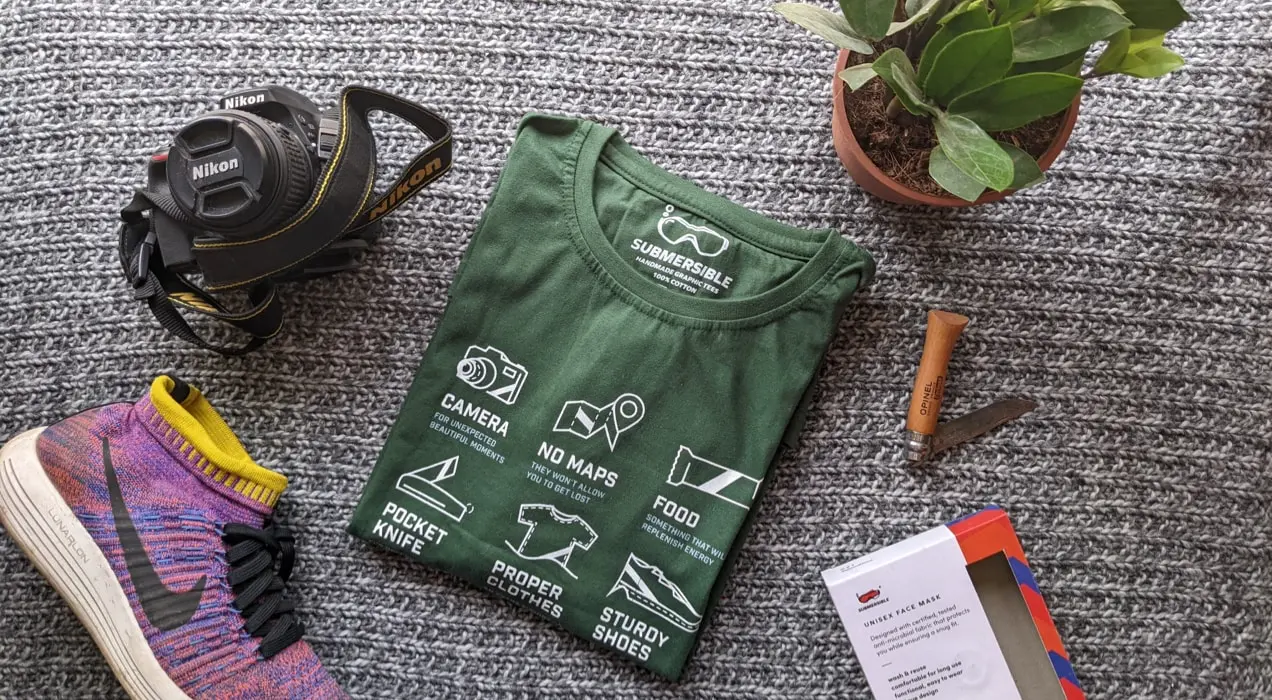 kaos hijau dikelilingi oleh barang-barang hiking