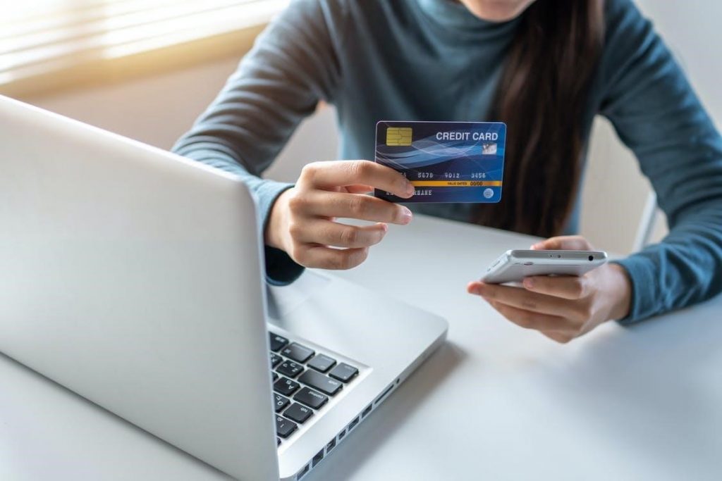 wanita memegang kredit untuk melakukan pembayaran online
