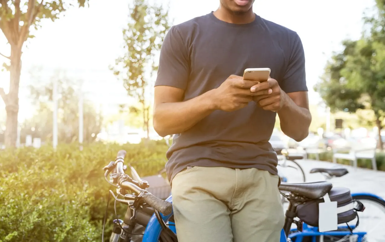 bărbat care se uită la telefon într-o plimbare cu bicicleta