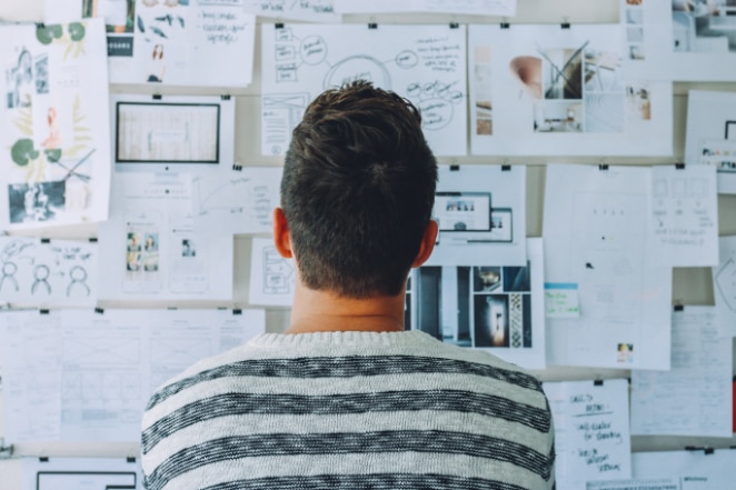 um homem olha para um quadro de humor de diferentes personas de compradores e ideias de design
