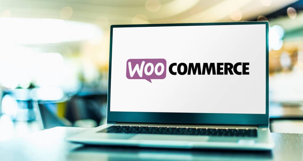 Uma tela de laptop exibe o logotipo WooCommerce