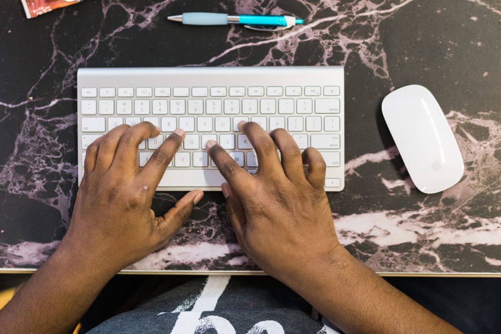 Mãos digitando no teclado para CTA eficaz