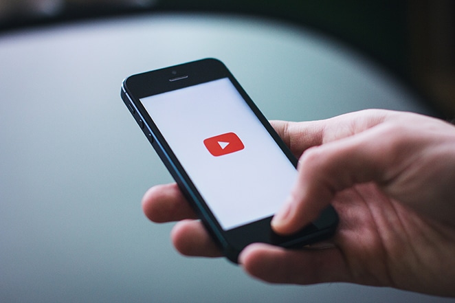 تحميل شعار youtube على الهاتف المحمول في يد الإنسان