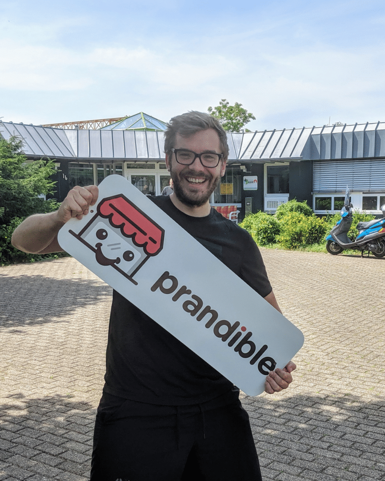 Man memegang tanda yang menampilkan logo Prandible