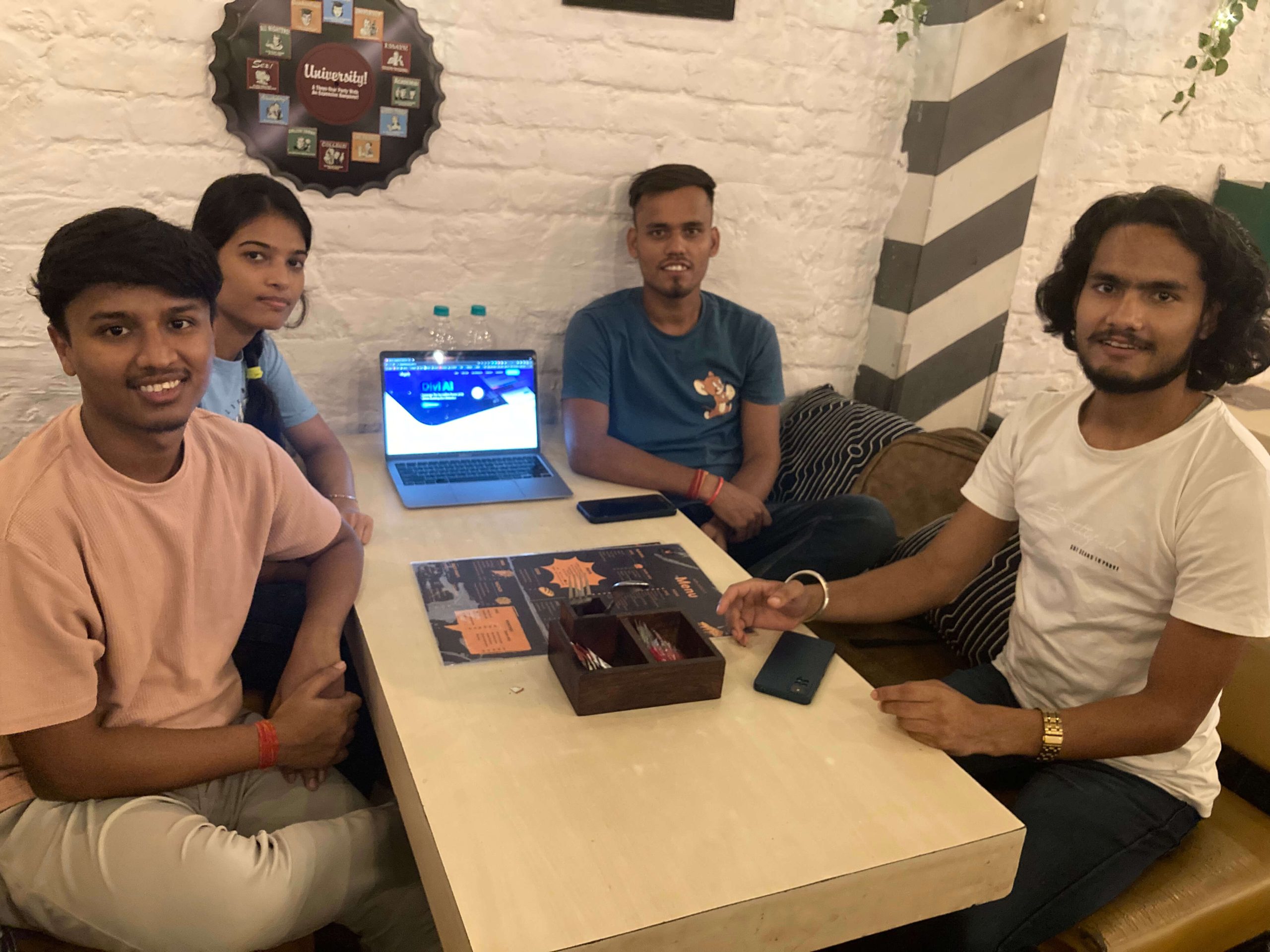 4 persone sedute attorno a una scrivania all'incontro del Divi Delhi NCR