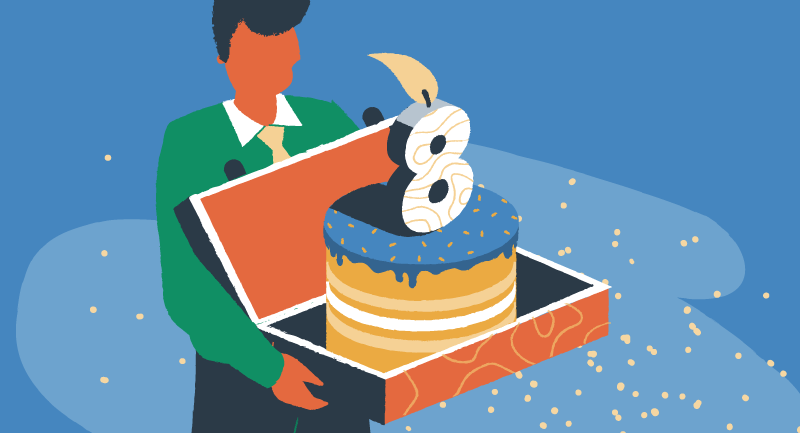 Un homme porte un gâteau d'anniversaire dans une boîte avec une bougie brûlante sur la forme du numéro 8.